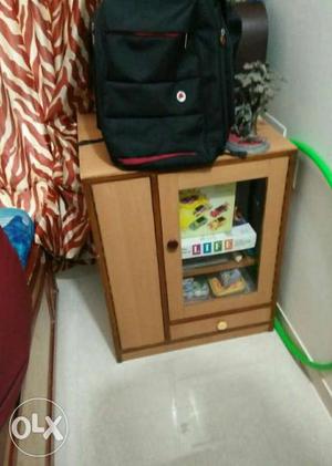 Brown Wooden Cabinet; Black And Red Backpack