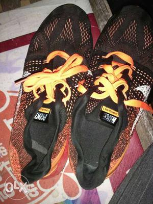 Pair Of Black And Orange Nike Soccer Cleats