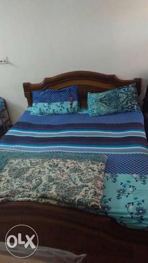 Brown Wooden Bed Frame With Blue-and-teal Bed Spread