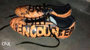 Pair Of Black And Orange Encounter Cleats