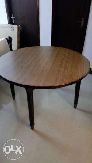 A four seater dining table along with 4 chairs is