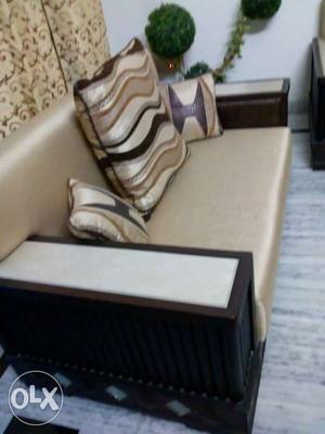 Brown Wooden Base Beige Padded Sofa With Three Pillows