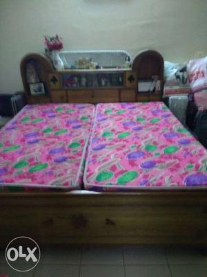 Brown Wooden Bed And Pink, Purple, And Green Floral Mattress
