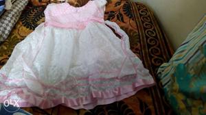 Cute frock of baby pink and white colour. Price