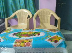 Two Brown Plastic Monobloc Chairs with two table