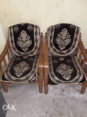 Two Brown Wooden Armchairs With Black-and-gray Pads