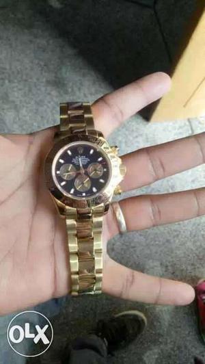 Round Black Rolex Chronograph Watch With Gold Chain Link