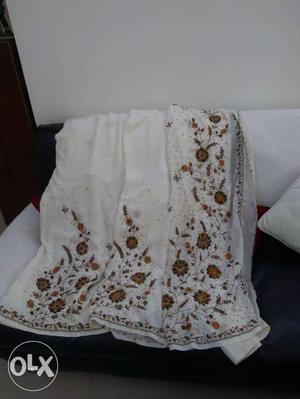 It is a white sari with side embroidery in stones