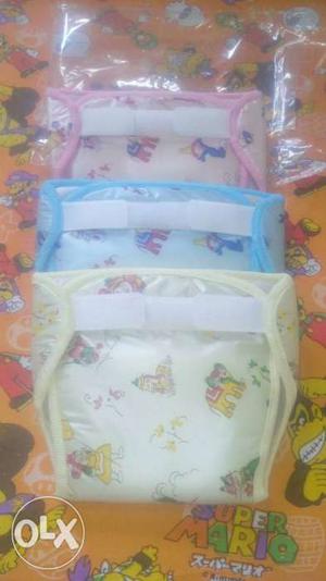 Three Yellow, Pink, And Blue Disposable Diapers