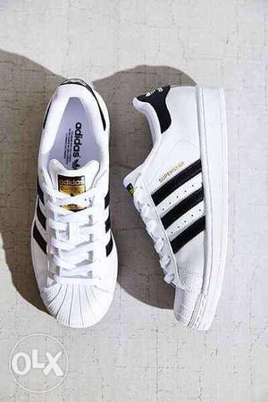 Pair Of White Adidas Superstars Sneakers