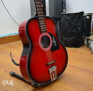 Red and black acoustic guitar best for beginners in half