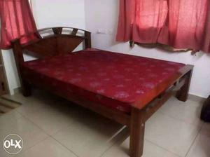 Brown Wooden Bed Frame And Red Bed Mattress
