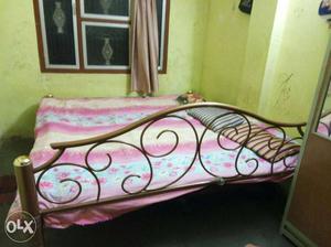 Pink, Beige, And White Floral Bed Cover And Brown Metal