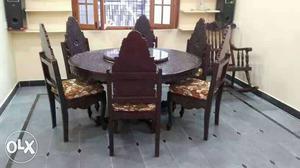 Round Brown Wooden Dining Table And Padded Chairs