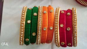 Three Red, Orange, And Green Silk Bracelets