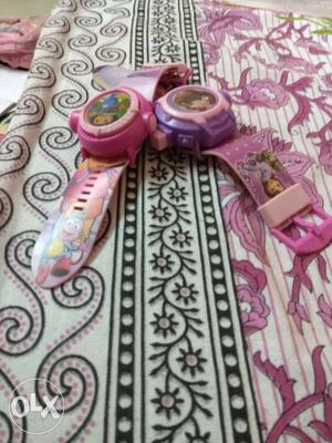 Two Purple And Pink Watches With Straps