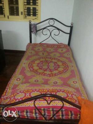 Black Metal Bed Frame With Pink-and-yellow Floral Blanket