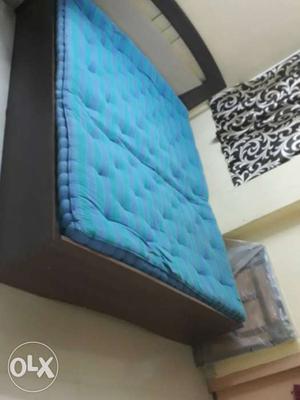 Brown Wooden Panel Bed With Blue Mattress