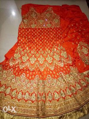 Orange colour silk gown with full embroidery and stones on