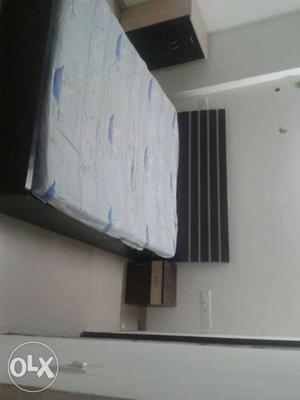 Black Wooden Bed With White And Blue Mattress