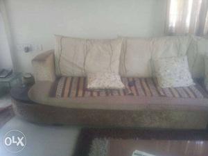 Long sofa with pillows and huge center table with sidecorner
