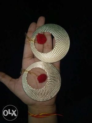 Round textured gold metal earrings with red pom