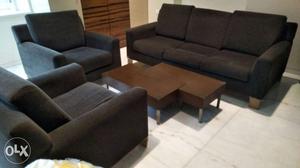 A comfortable 3 seater sofa with 2 arm chairs and a coffee