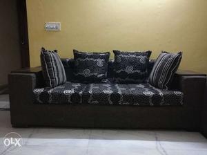 Brown And Gray Fabric Couch With Four Black-and-white Throw