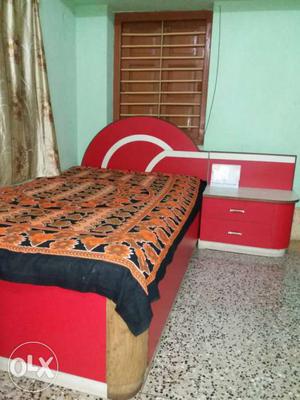 Single bed with a bed table & mattress.