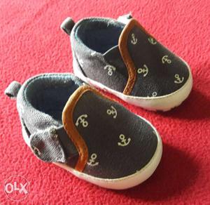 Navy blue slip on shoes for baby boy aged 0 to 3 months.