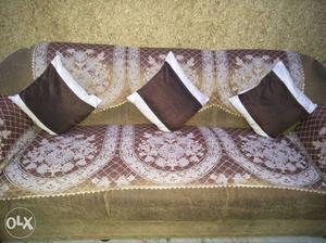 Brown Fabric Couch And Three Brown-and-white Throw Pillows