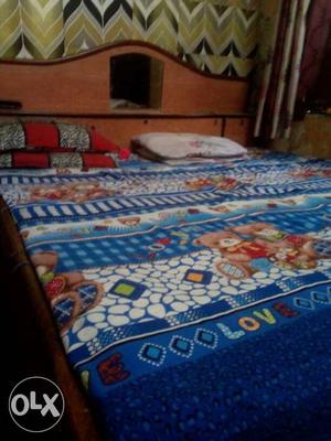 Brown Wooden Bed Frame With Blue And White Bed Sheet