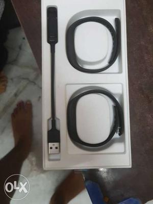 Two Black Activity Trackers And Charger With Box