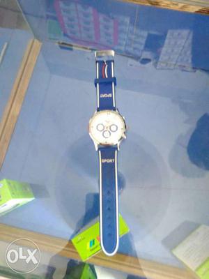 Round Gold Watch With Blue And White Strap
