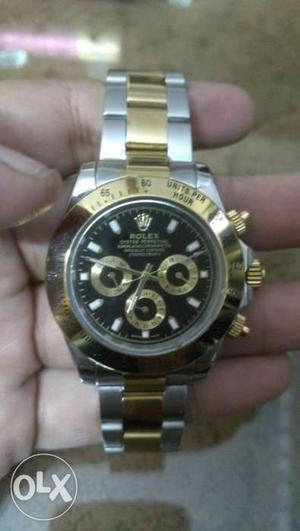 Round Black Faced Rolex Chronograph Watch With Gold And