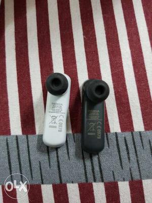 Two White And Black Nokia Bluetooth Earpiece