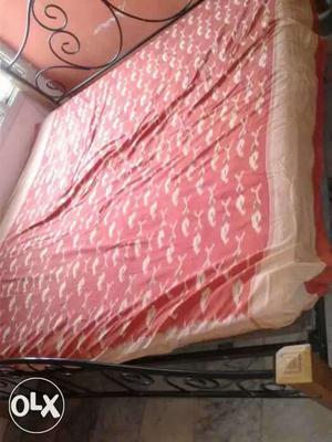 Red And Beige Bed Sheet And Brown Metal Bed Frame
