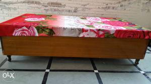 Brown Wooden Bed With Red And Pink Floral Bed Sheet