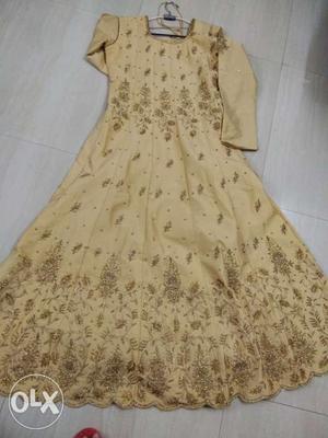 Golden gown with heavy stone work. With net