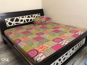 Black And White Wooden Bed With Green, White, And Pink