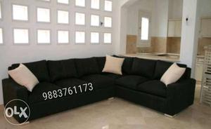 Black Fabric Sectional Couch With Three White Throw Pillows