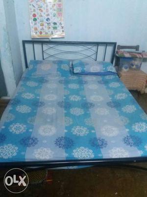 Black Metal Bed Frame And Blue Floral Bed Mattress