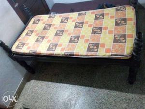 Black Wooden Bed Frame With Orange And Yellow Mattress
