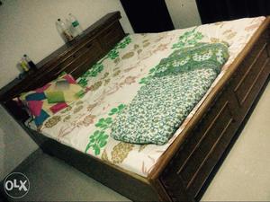 Green And White Floral Bed Sheet And Brown Wooden Bed