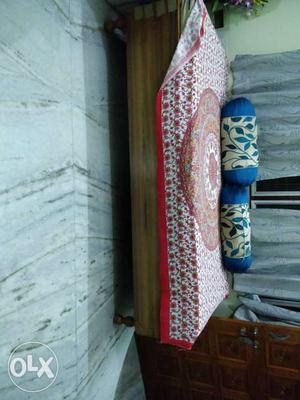 Brown Wooden Couch With Red And White Floral Sheet