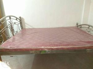 Gray Metal Bed Frame With Red And Brown Floral Mattress