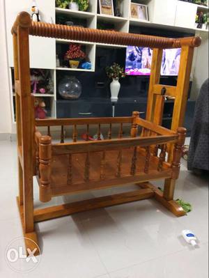 A brand new teak finished wooden cradle which can