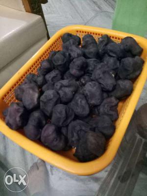 Black Dried Fruits And Yellow Plastic Container