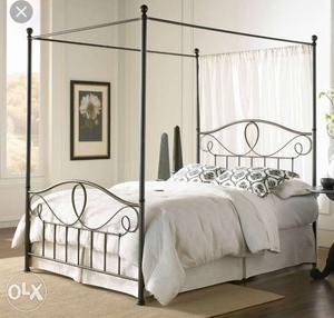 Black wrought iron bed with post, and a pair of