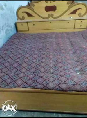 Brown Wooden Bed Frame With Purple Mattress